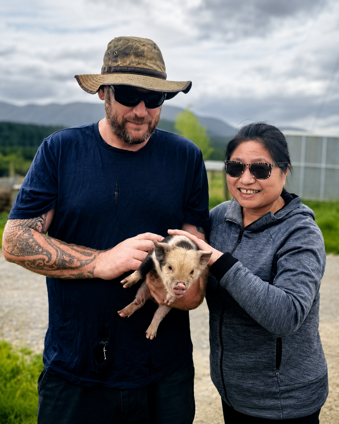 A guardian standing with a companion while holding a piglet in a rural landscape